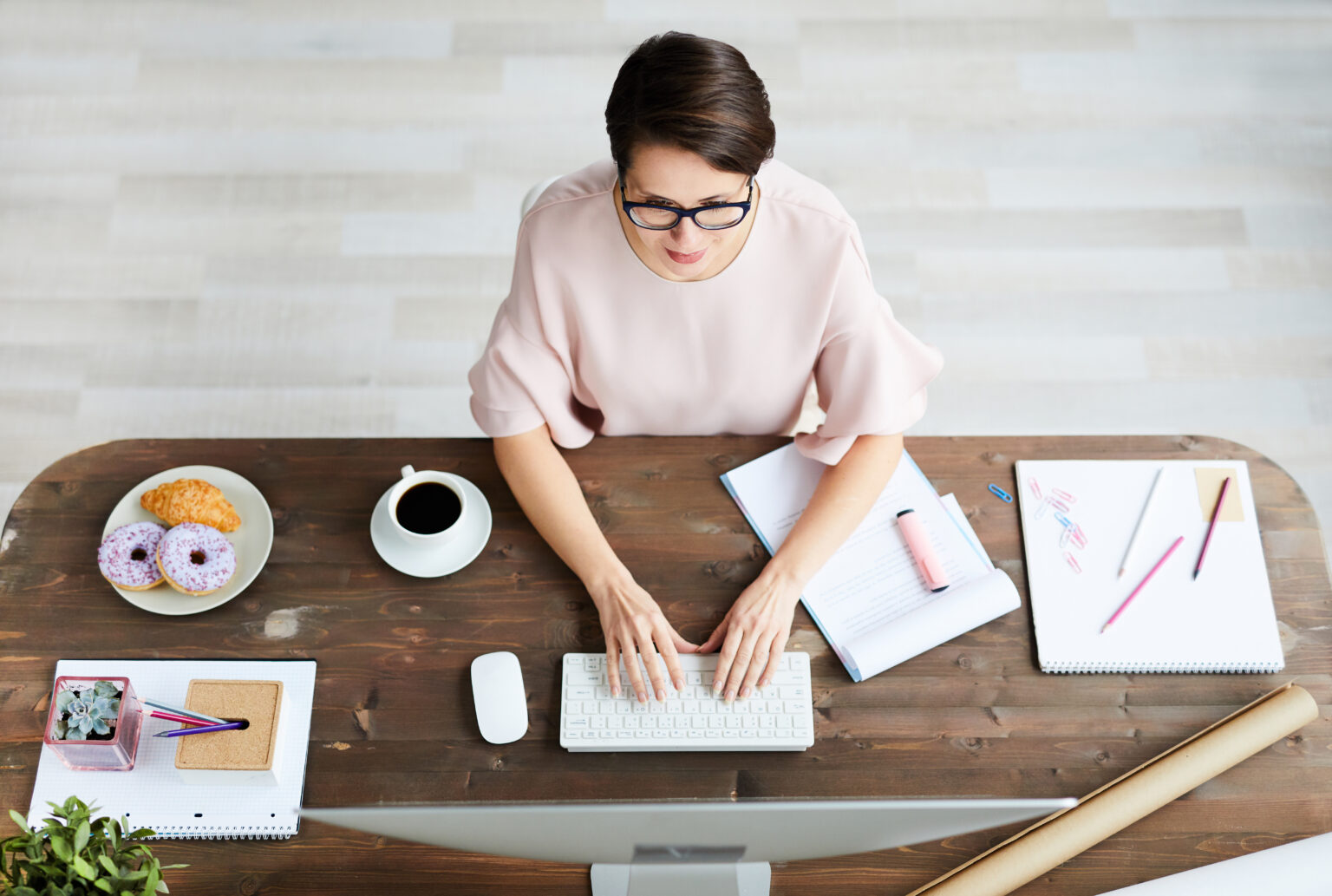 There is a young elegant businesswoman sitting in front of computer monitor, typing and searching for new creative ideas, illustrating the usage of an enterprise resources planning (ERP)