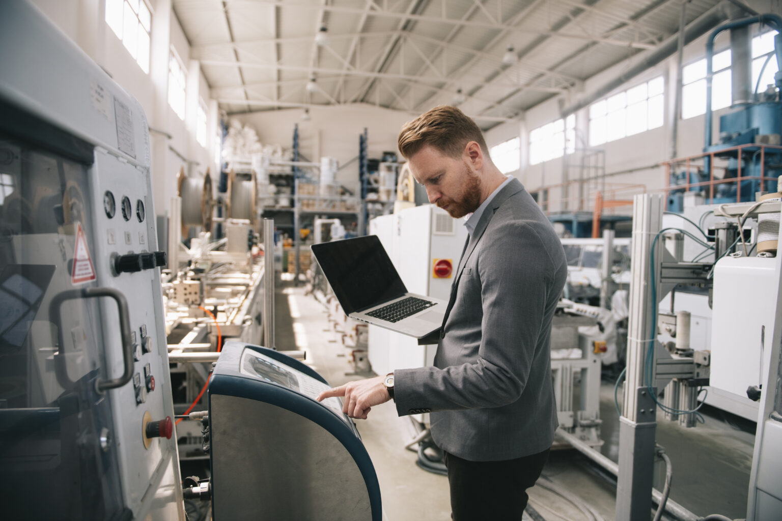 There is a manager checking machines at the factory, illustrating Business Process Management