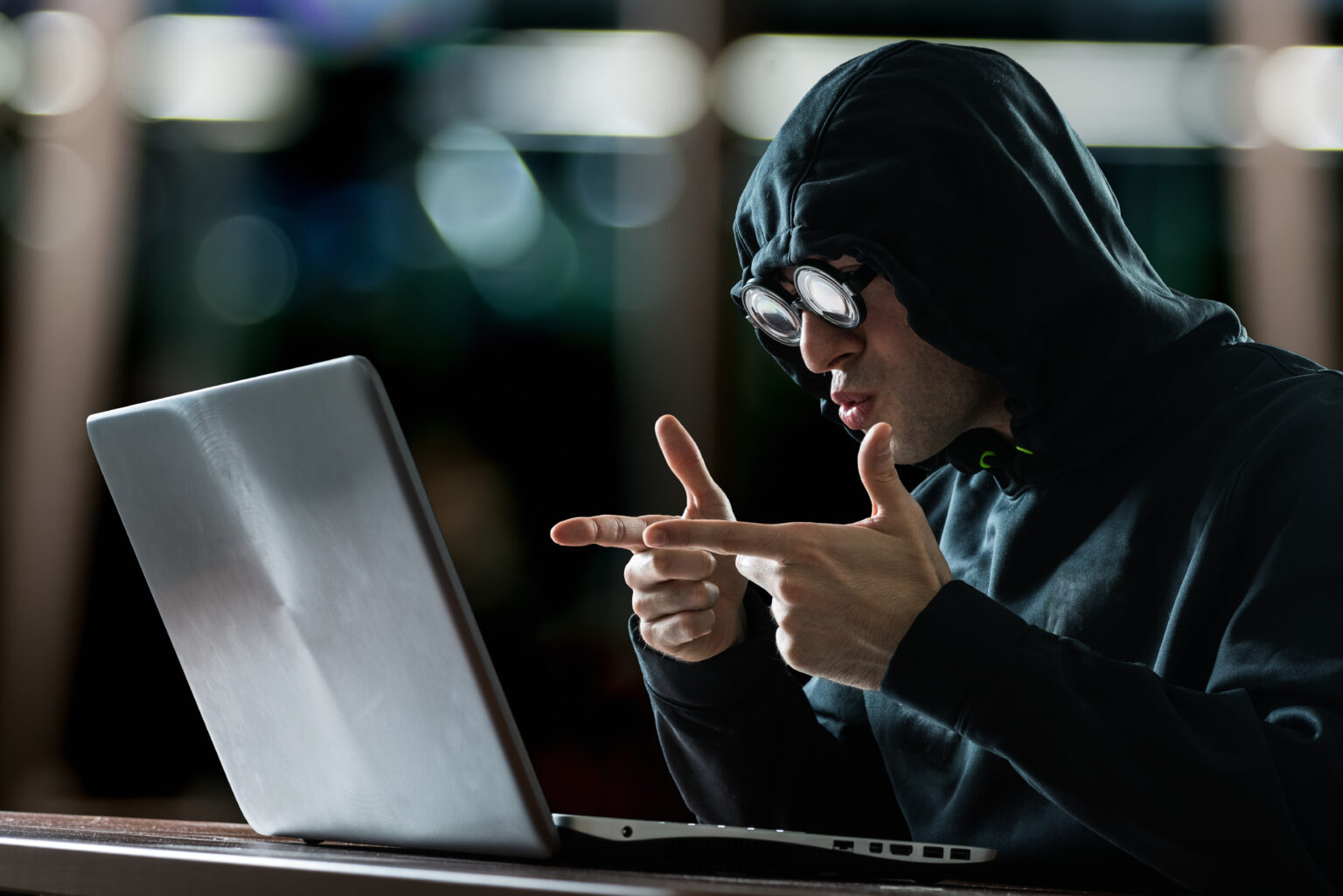 Enjoyed and really happy hacker in front of his computer after executing commands for illustrating supply chain management software usage SCM